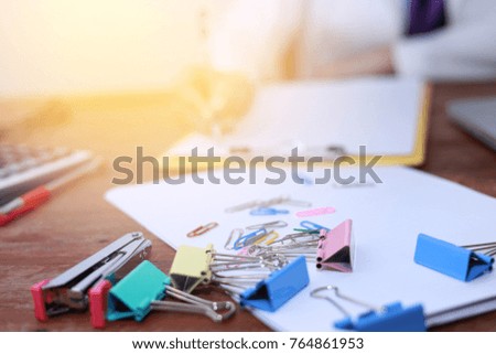Business woman taking business notes  using laptop computer pen calculator paper clip paper work on wood table  . 