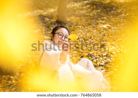 Lovely asian girls in the park with yellow leaves full of deciduous leaves
