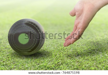 A male hand bowling and releasing a wooden lawn bowling ball on a green lawn grass surface -3D render