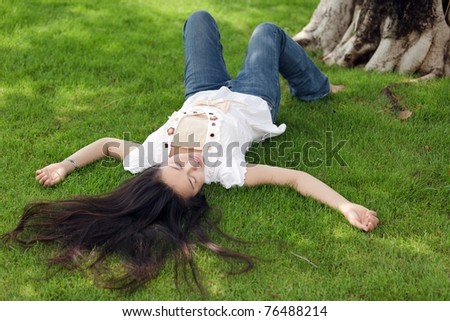 asian woman with long hairs lying on grass, Thailand