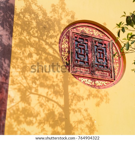 tree shadows and temple wooden window on buddhist wall