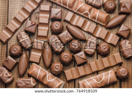 Background of chocolates, bars and sweets, free space for text, close up