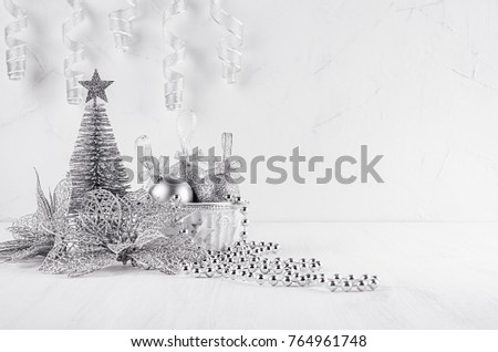 Christmas glitter silvery tree and poinsettia on white modern background. Christmas home decor.