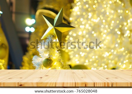 Empty wooden table on a background of the Christmas charts, background of free space for you with wooden desk and balls and tree