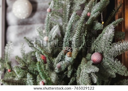 Christmas decor. Branches of a snow-covered tree with red balls in a wooden box.