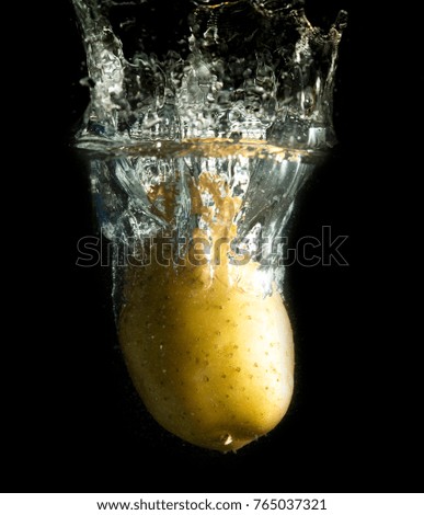 potato in water with splashes on a black background