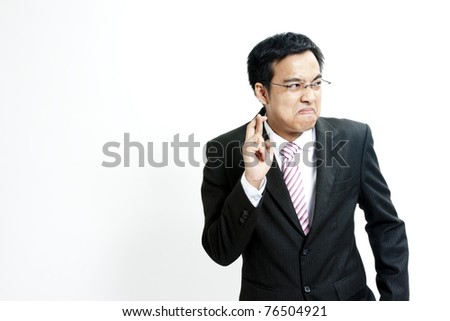 Superstitious - entrepreneur with crossed fingers over white background