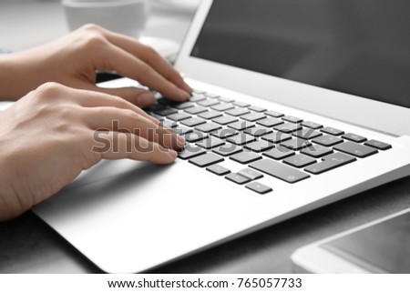 Woman using laptop, closeup