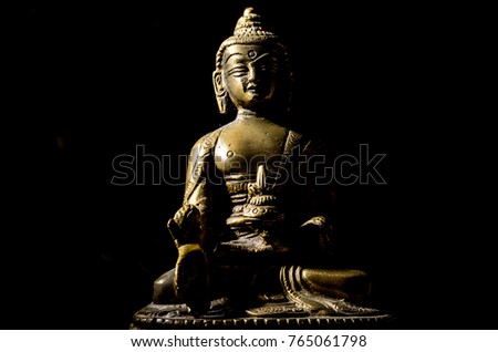 Bronze buddha in smoke isolated on black background