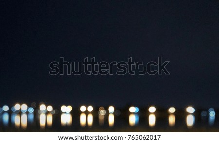Abstract blurred night and inverted reflection in water, and skyline as background.