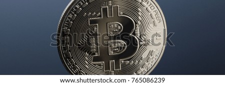 Coin of crypto currency bitcoin on a gray-blue background with reflection subject gold exchange pyramid on money in connection with the growth or fall exchange rate closeup.