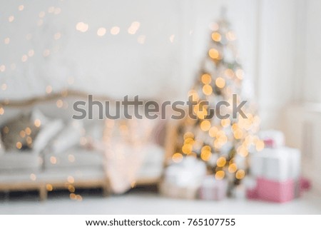 Blurred background. Luxury living room interior with sofa decorated chic Christmas tree, gifts, plaid and pillows.