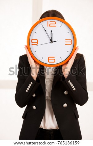 cute woman holding a clock as a symbol of time management