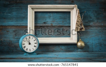 vintage wood picture frame and alarm clock on wooden background