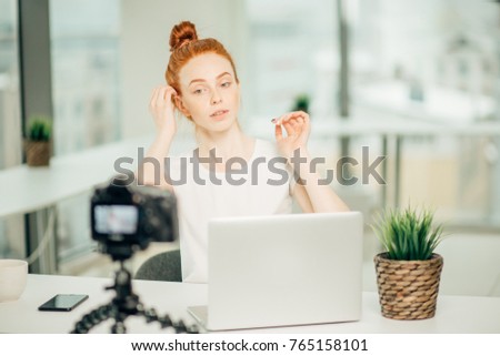 young woman broadcasting a hair tutorial for her video blog
