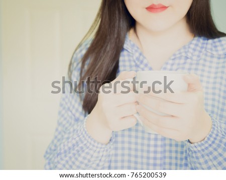 white skin of beauty woman smile with red mouth in blue sleepwear hold white cup of coffee and serve for drink in morning time