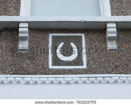 Image of a horseshoe on a wall of a house. Horseshoe is a symbol of good luck and happiness.