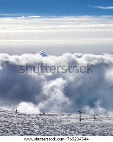 View on ski resort with ropeway in sun cloudy mountains at evening. Caucasus Mountains in winter, Georgia, region Gudauri.