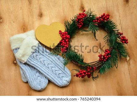 Christmas wreath ,winter gloves and a heart shape Christmas gift on wooden background
