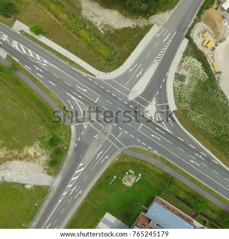 Empty crossroads with icons to the lanes, perpendicular to the drone from the air