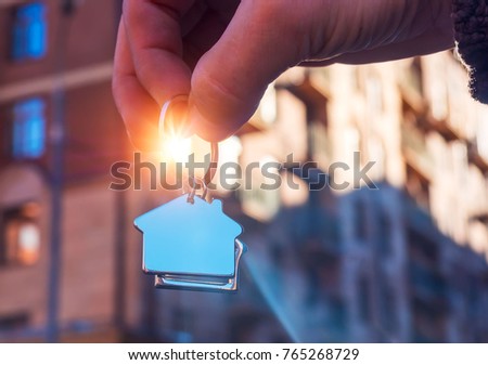 Holding house keys on house shaped keychain.