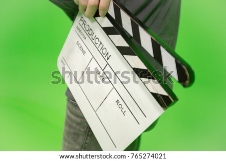Video producer man holding movie clapper on green background