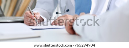 Stethoscope head lying on medical forms closeup while medicine doctor working in background. Patient history list visit check 911 medical calculation and statistics healthy lifestyle concept Royalty-Free Stock Photo #765294904