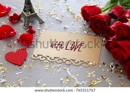 Valentine's day background. Beautiful bouquet of roses next to letter with text WITH LOVE on wooden table