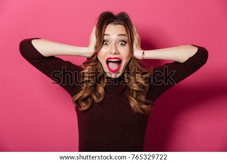 Image of shocked excited woman standing isolated over pink background. Looking camera.