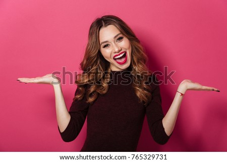 Image of amazing lady standing isolated over pink background. Looking camera holding copyspace in hands.