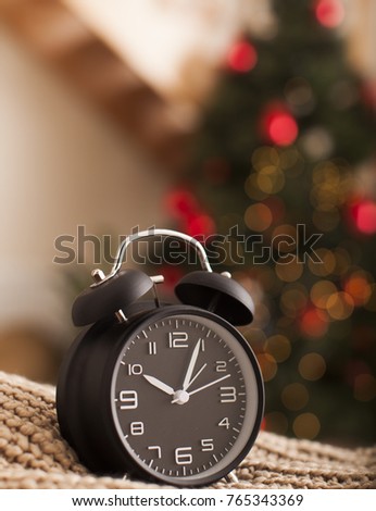 Old Vintage Alark clock on blur background of New Year Tree. blurry picture top of Christmas tree with lights and vintage alarm clock for background, filtered tones. New Year Time. Christmas Theme