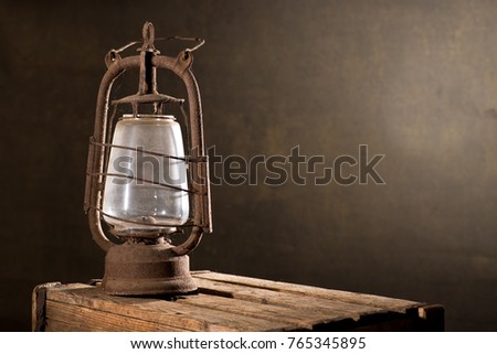 Old Rusty Lantern on the Wooden Desk in the Attic