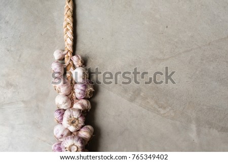 High angle view of plaited dried garlic on concrete background (selective focus)