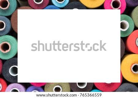 Colored Sewing threads as frame, text ready, textile background
