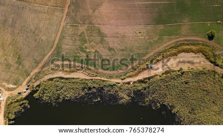 Aerial view of small calm lake in a flat area. Shot on a partly cloudy day in october. 