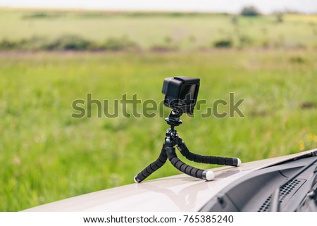 Action camera on flexible tripod on the hood of car recording  time-lapse, copy space