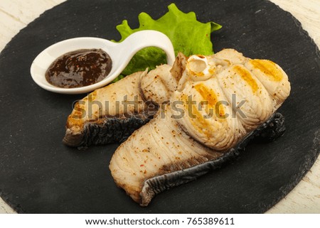 Grilled shark steak with pepper sauce and salad leaves