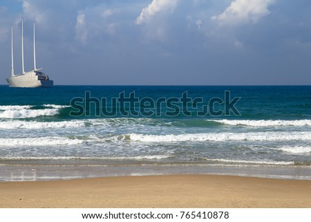 A harmonious background picture of the beach in Tel Aviv with a huge yacht anchored in front of the beach