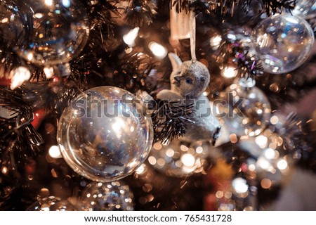 Cute Christmas tree decoration toy in the form of a baby penguin among glass balls and garlands