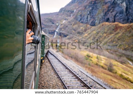 Tourist taking pictures with a dslr camera during trip on the famous scenic train line in Norway going from Myrdal to Flam