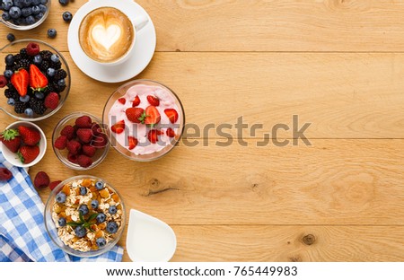 Tasty breakfast with light greek yogurt, muesli, fresh organic berries and latte coffee. Low fat morning meals and healthy start of the day. Detox and diet concept, top view, copy space