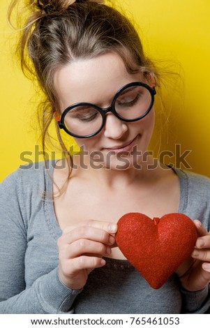 Funny nerdy woman with a red heart on a yellow background. Valentine's Day