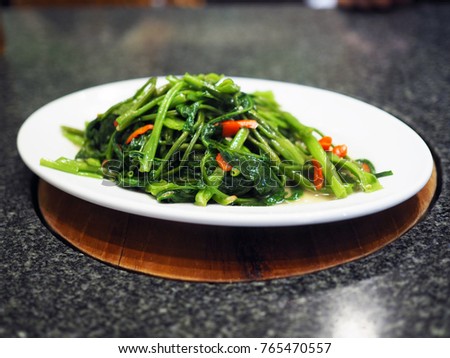 Plate of stir fried morning glory with oil and chili, healthy concept. Selective focus.