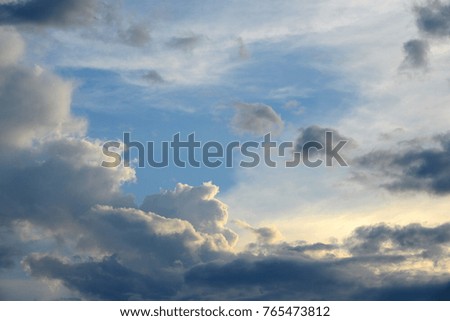 White and dark clouds against blue sky.
