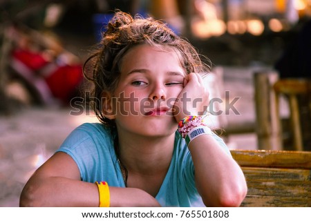 A European-looking girl with a face expressing boredom and anticipation. Asian cafe, travel with children, local cuisine. The background is blurred. Royalty-Free Stock Photo #765501808