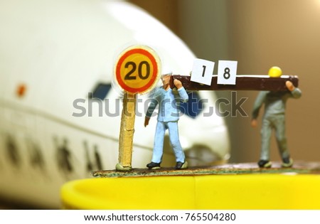 Construction worker figure model carry wood and paper with english text number represent new year 2018 with miniature plastic plane as a background.