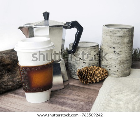 coffee and espresso on wood table with warm blanket and pine cones for christmas and winter scene of styled stock photography