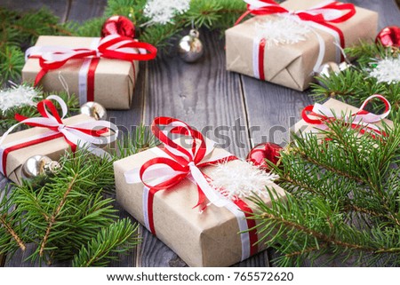 Christmas background with fir tree and decorations and gift boxes on wooden board.