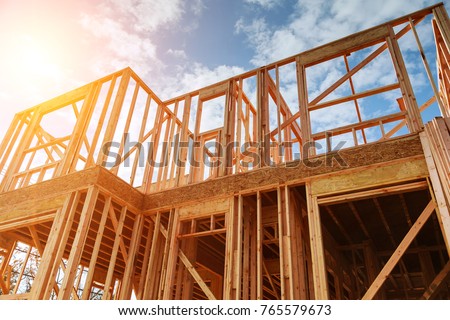 New residential construction home framing against a blue sky. Roofing construction. Wooden construction Royalty-Free Stock Photo #765579673