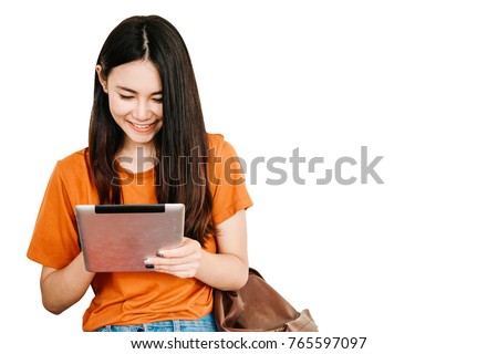 A young or teen asian girl student in university smiling and look at the tablet computer in summer holiday. Girl use tablet on isolated background. Royalty-Free Stock Photo #765597097